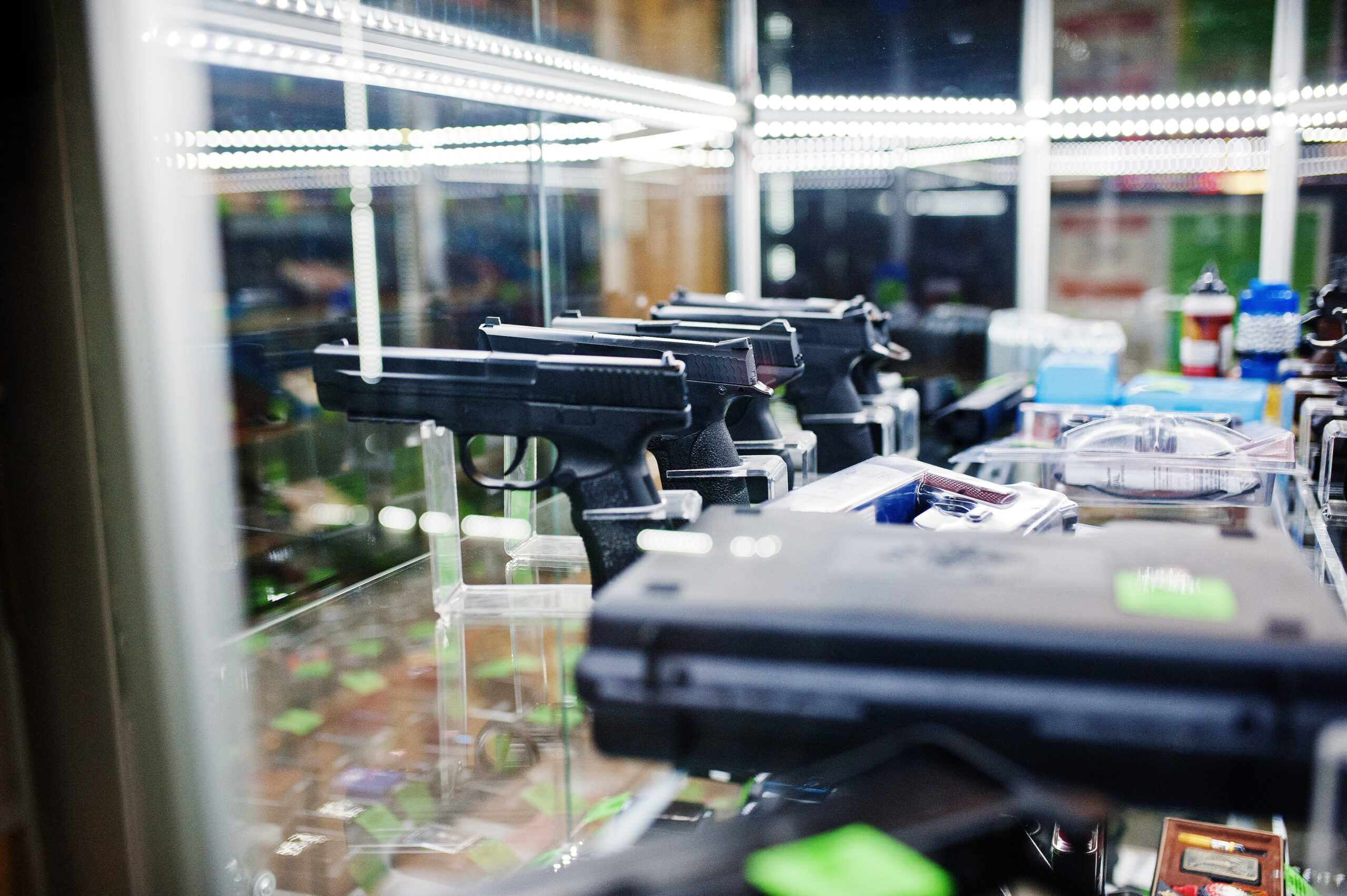 Different guns and revolvers on shelves store weapons on shop center.